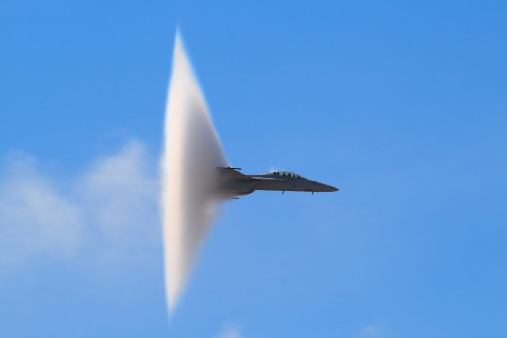 Vapor cone engulfs jet as it passes through the speed of sound.